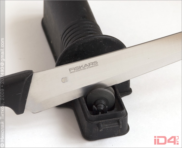 Ножеточка компании Fiskars Brands, Inc. и нож производства той же компании (направляющая крышка снята) Ножеточка компании Fiskars Brands, Inc. и нож производства той же компании (направляющая крышка снята)